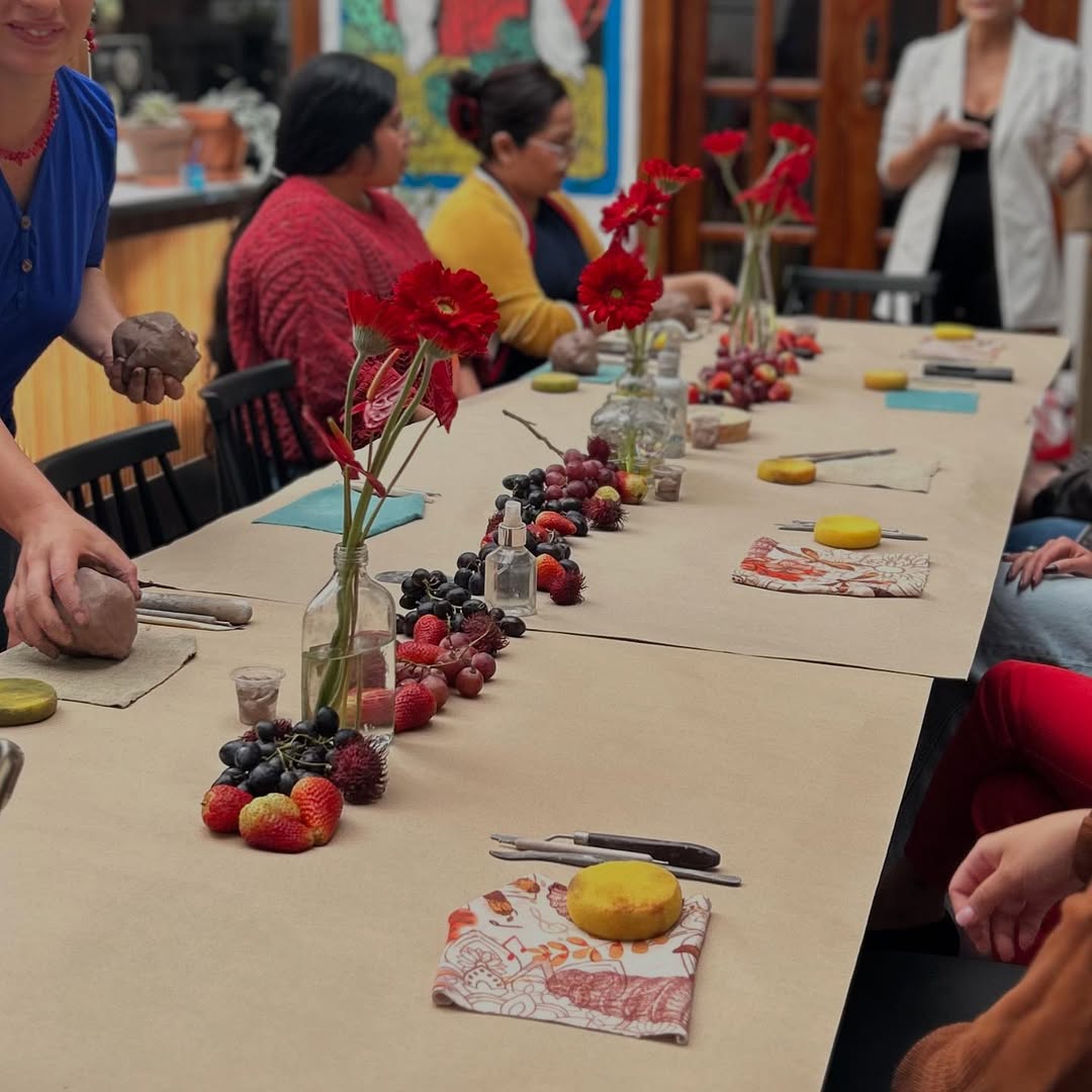 Mesa de actividad creativa con flores y frutas en taller de MusasConscientes